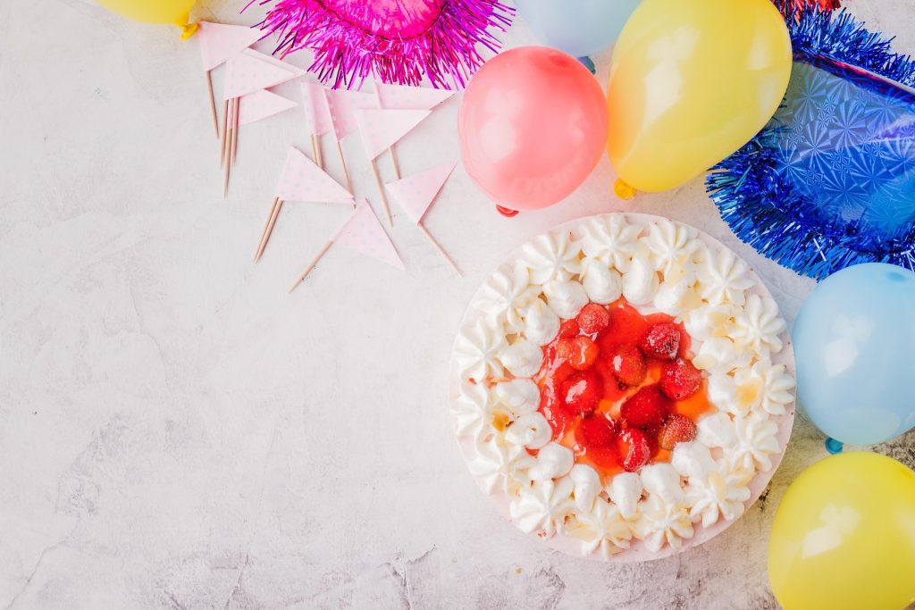 Party decorations and a festive cake on a table.